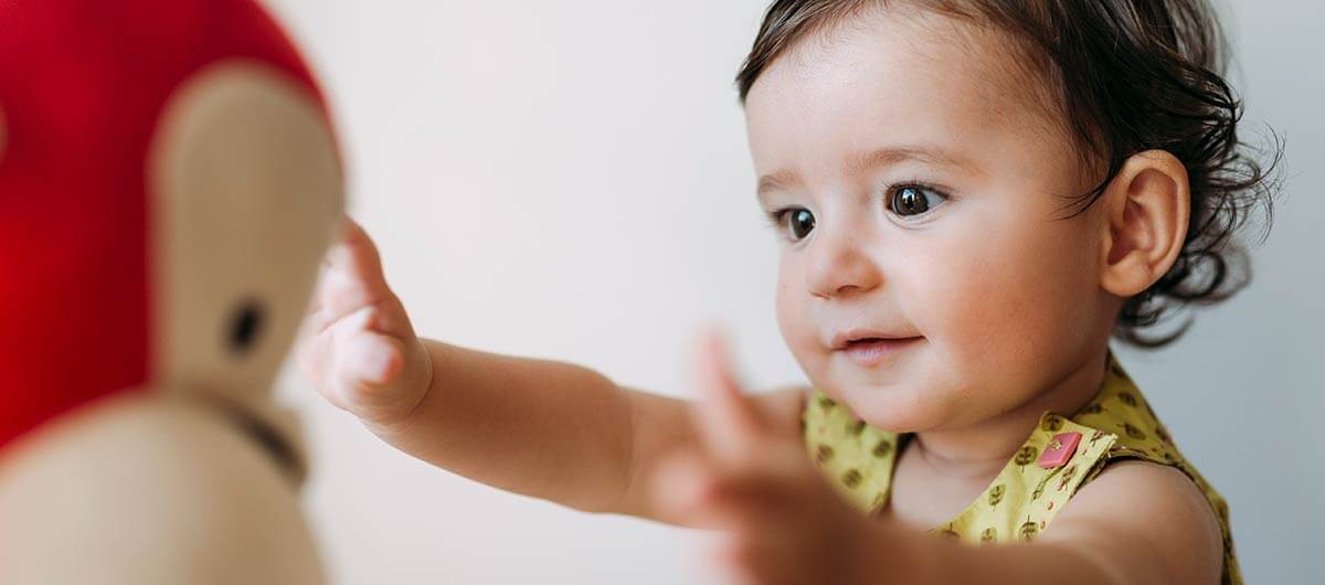 adorable baby girl reaching for a toy